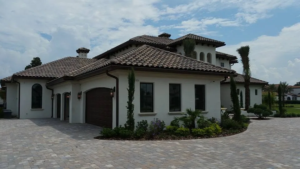Mediterranean white stucco home barrel tile roof bronze gutters paver driveway s